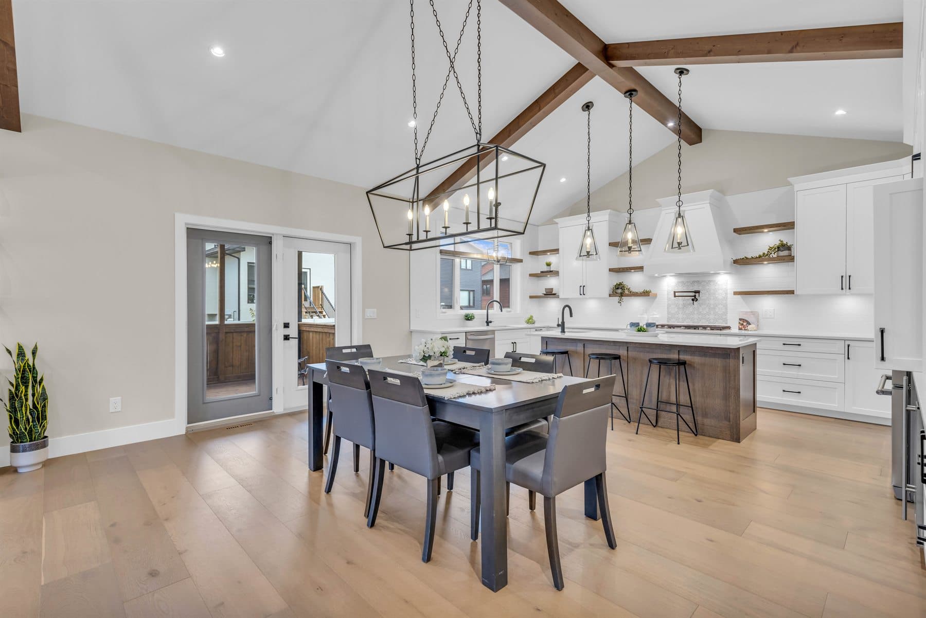 Open dining and living space with wood beams and large windows